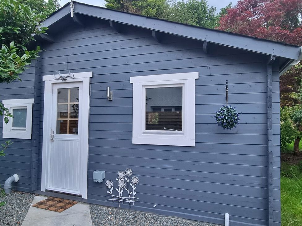 An exterior view of a lodge with a door and windows at 2 bed Lodge near Dunoon on the Shore Front, Innellan near Dunoon