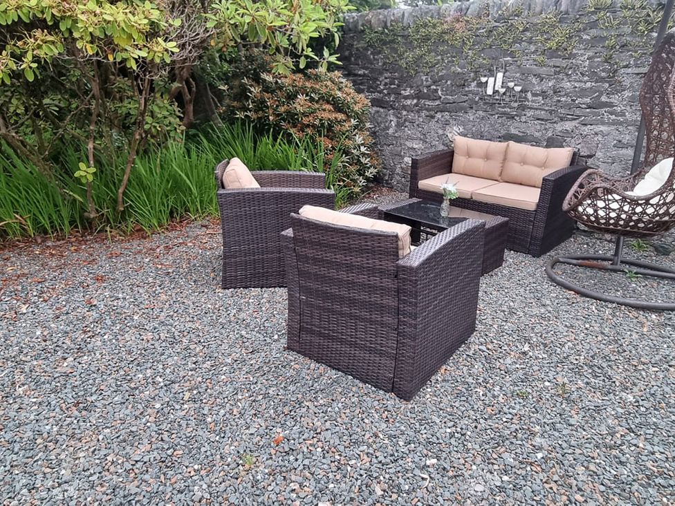 An outdoor seating area with a sofa and armchairs at 2 bed Lodge near Dunoon on the Shore Front in Innellan near Dunoon