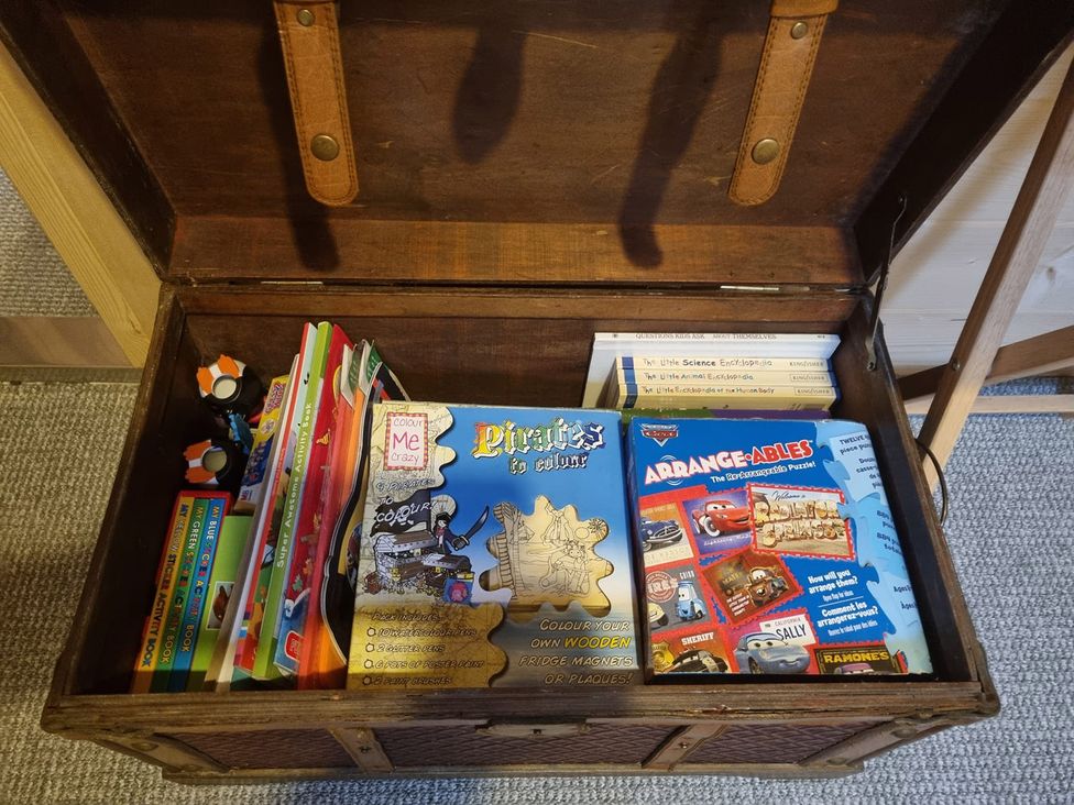 A wooden chest containing books and coloring materials at 2 bed Lodge near Dunoon on the Shore Front, Innellan near Dunoon