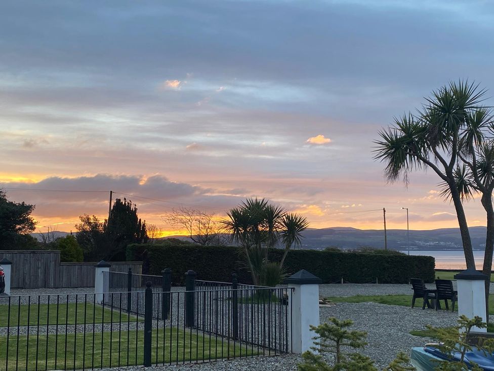 A view of sunset with palm trees and grassy area at 2 bed Lodge near Dunoon on the Shore Front Innellan near Dunoon