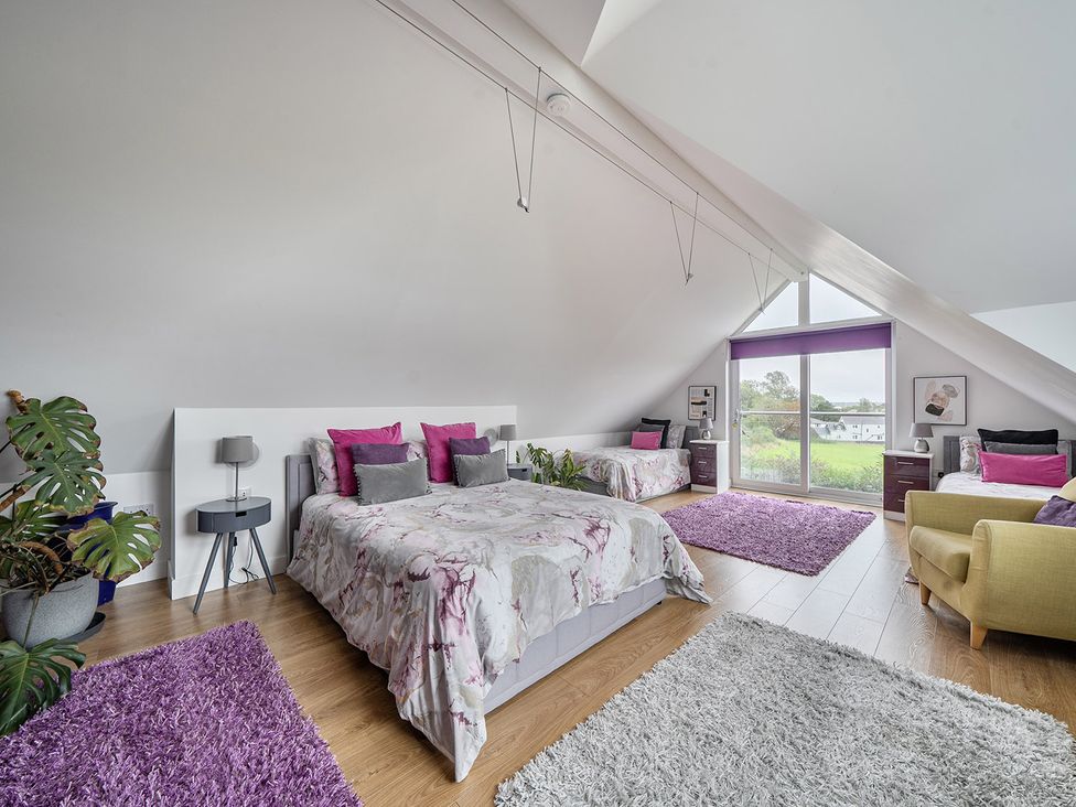 A bedroom with beds and a window at 5 Bed House, Sleeps 14 with Hot Tub and Bar, Tavistock