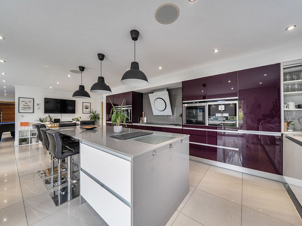 A kitchen with bar stools and a kitchen island at 5 Bed House, Sleeps 14 with Hot Tub and Bar Tavistock