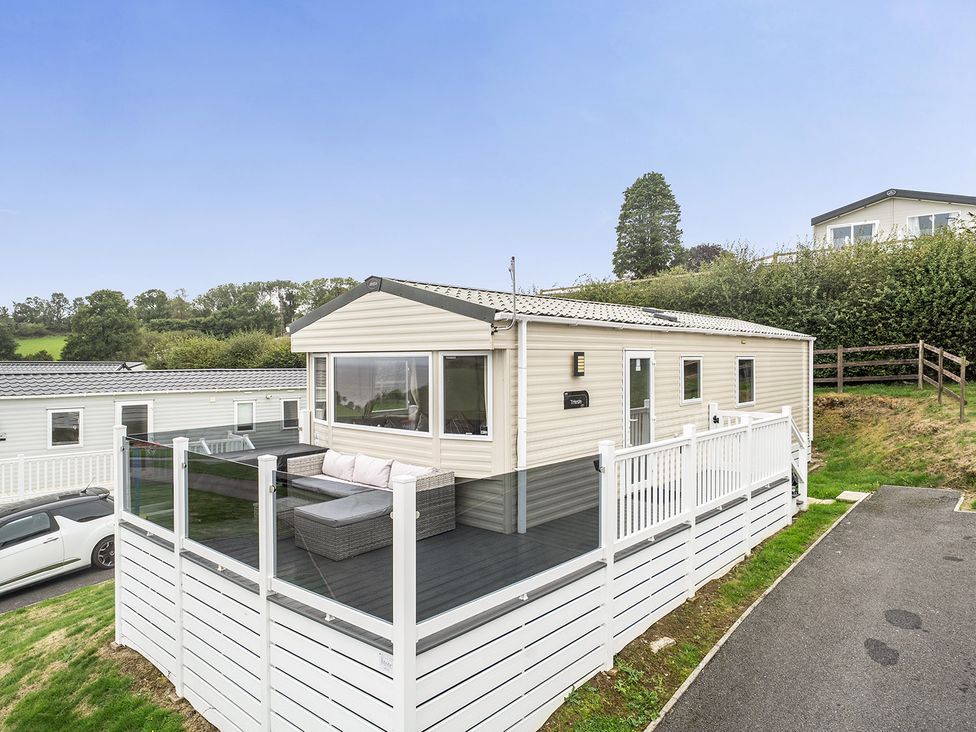 A caravan with a deck and sofa at Ty dee seaview escapes in Looe