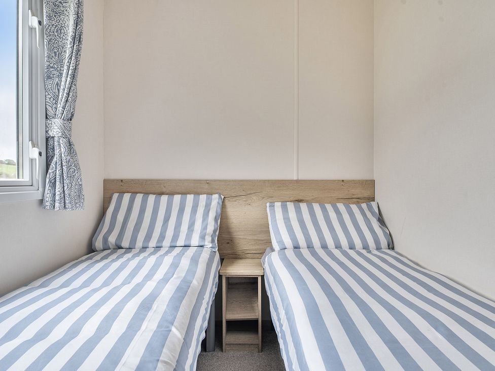 A bedroom with two single beds and a window at Ty dee seaview escapes in Looe