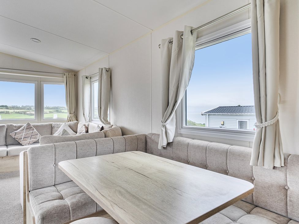 A living room with a sofa and table at Ty dee seaview escapes in Looe