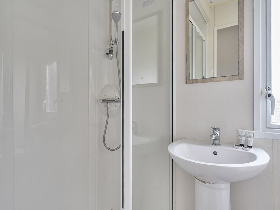A bathroom with a shower and sink at Ty dee seaview escapes in Looe
