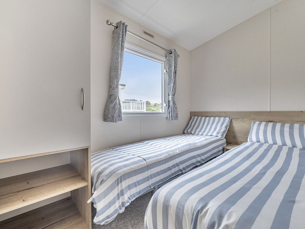 A bedroom with two single beds and a window at Ty dee seaview escapes in Looe