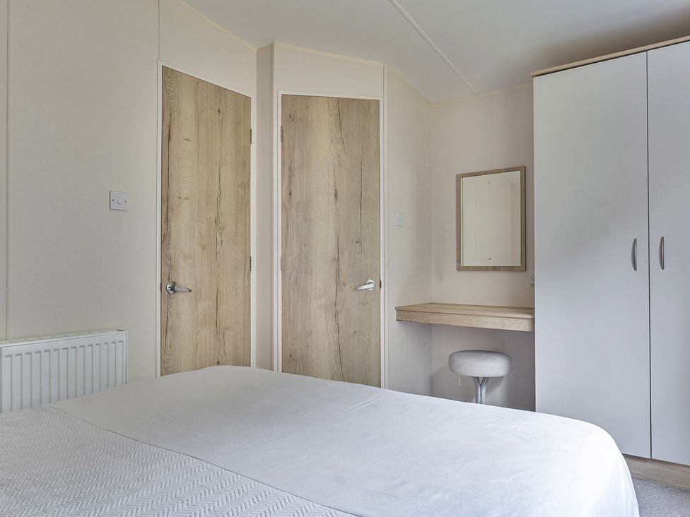 A bedroom with a bed and a table at Ty dee seaview escapes in Looe