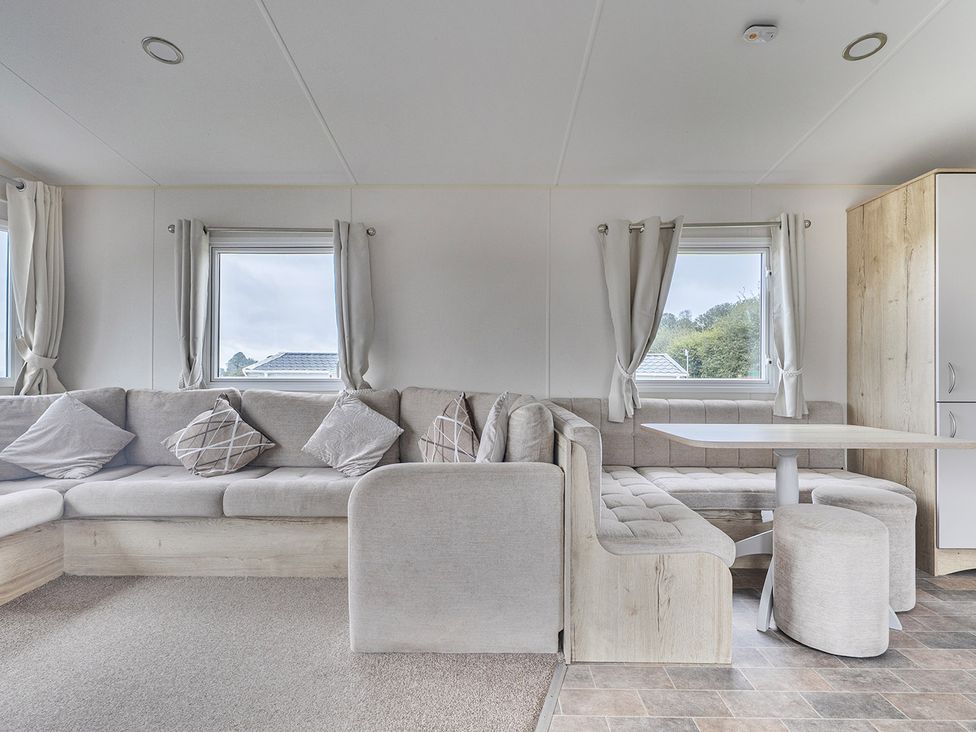 A living room with a sofa and table at Ty dee seaview escapes in Looe