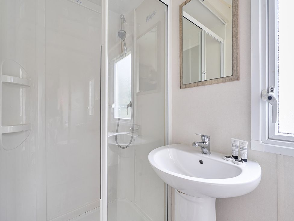 A bathroom with a shower and sink at Ty dee seaview escapes in Looe