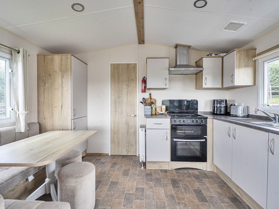 A kitchen with cabinets and appliances at Ty dee seaview escapes in Looe
