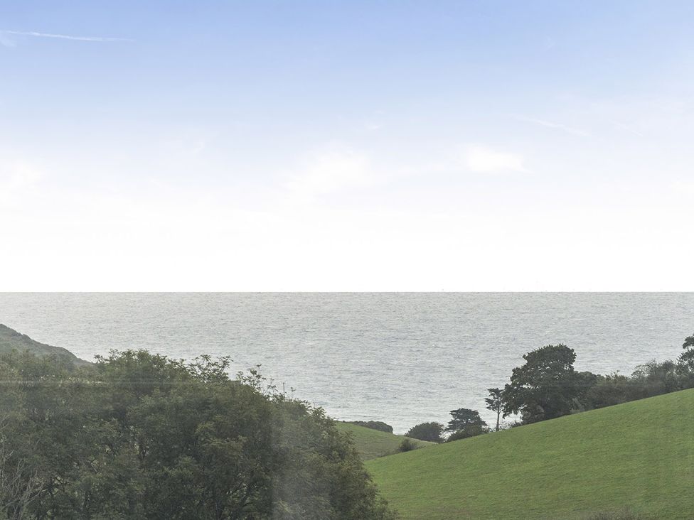 A view of the ocean and hills at Ty dee seaview escapes in Looe