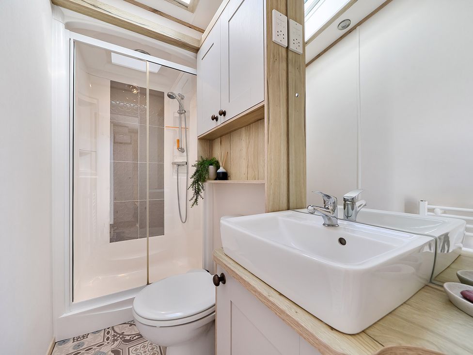 A bathroom with a shower, toilet, and sink at 2 Bed Caravan, Sleeps 4 with Sea Views, West Lulworth