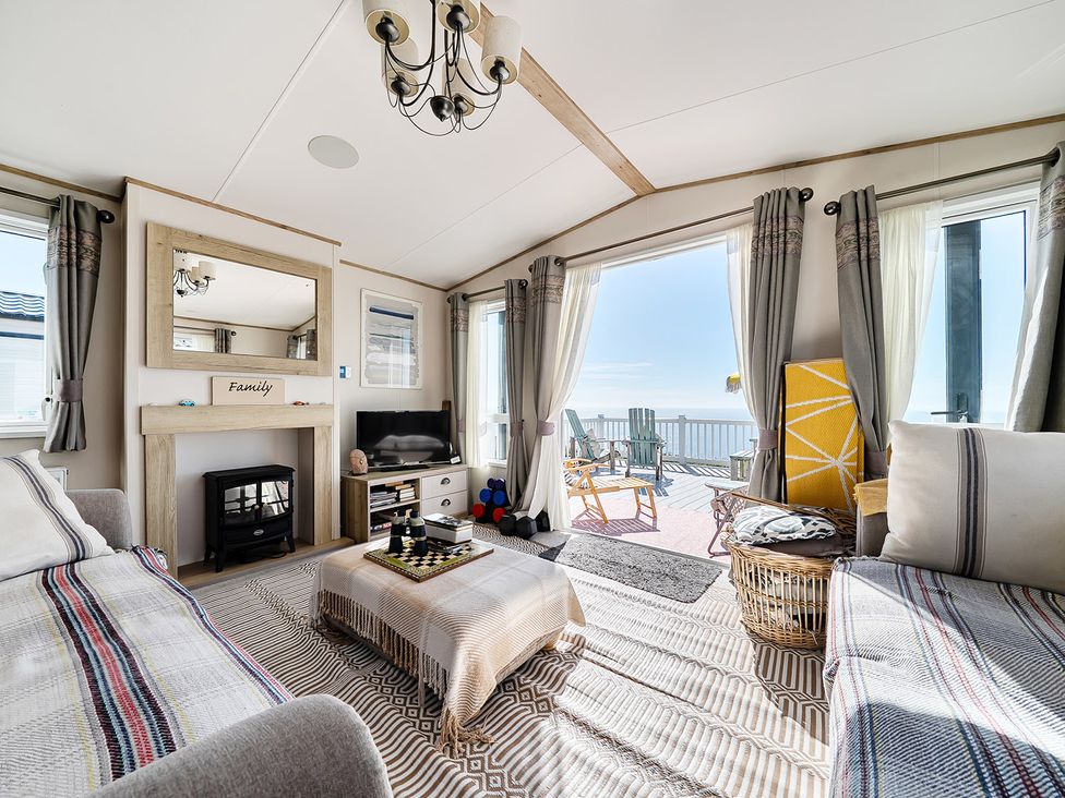 A living room with a fireplace and television at 2 Bed Caravan, Sleeps 4 with Sea Views, West Lulworth