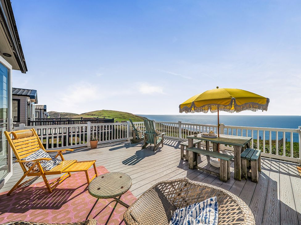 An outdoor deck with seating and a table at 2 Bed Caravan, Sleeps 4 with Sea Views, West Lulworth