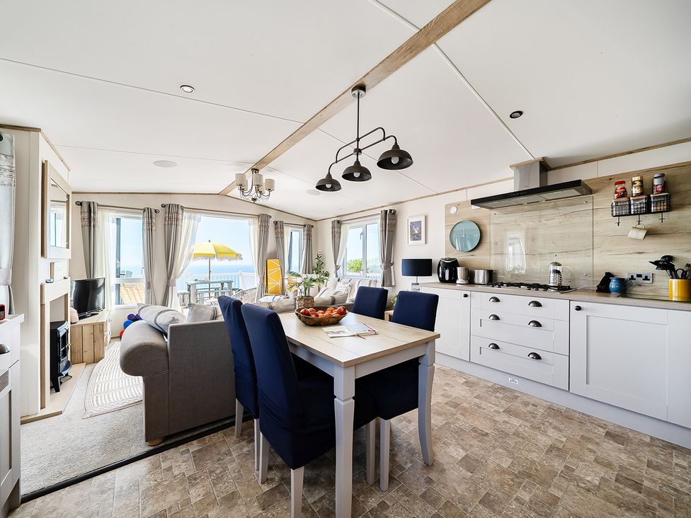 A kitchen with dining table and sofa at 2 Bed Caravan, Sleeps 4 with Sea Views, West Lulworth