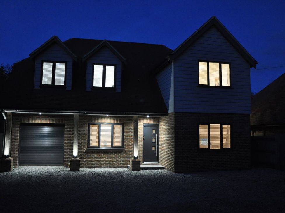 A house with illuminated windows at Berisal in Ashford