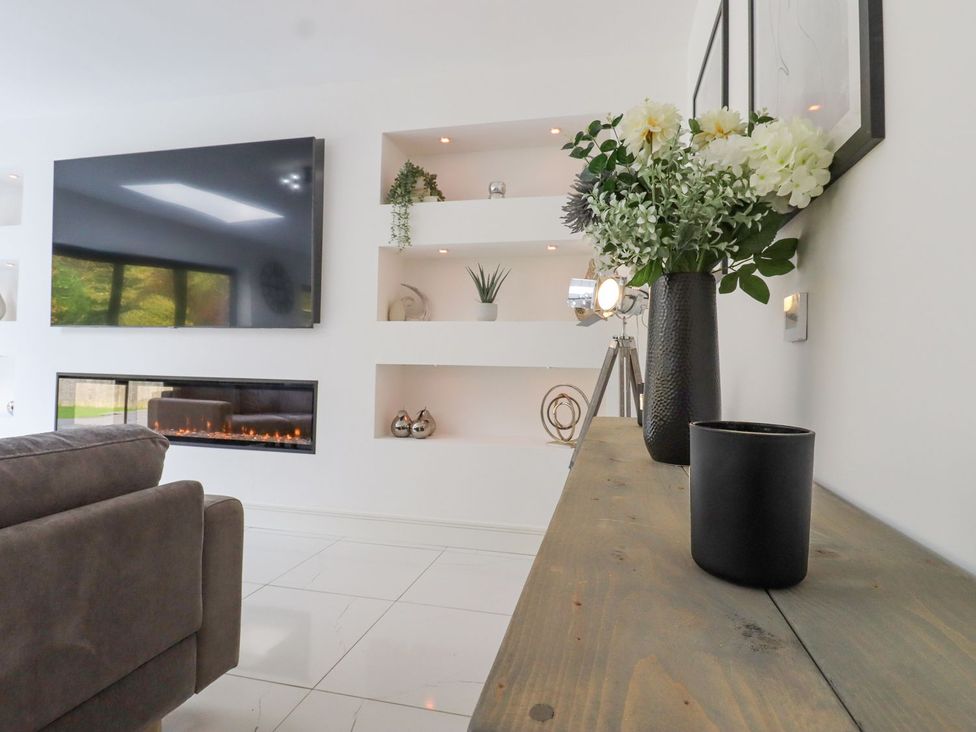 A living room with a television and an electric fireplace at Berisal in Ashford
