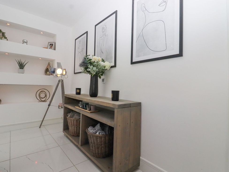 A hallway with a wooden table and decorative items at Berisal in Ashford