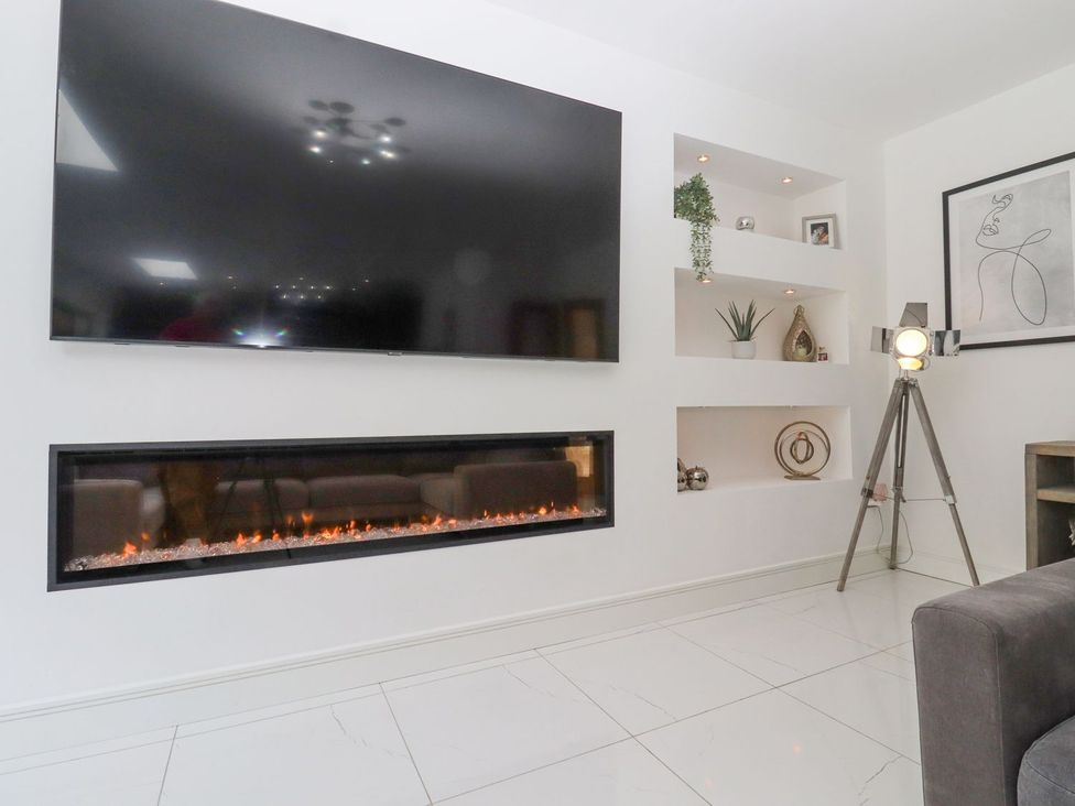 A living room with a television and electric fireplace at Berisal in Ashford