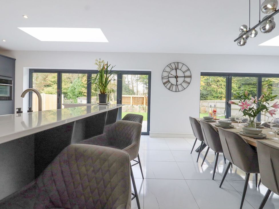 A kitchen with a dining area and bar stools at Berisal in Ashford