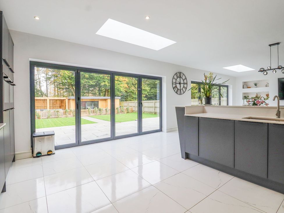 A kitchen with glass doors and skylight at Berisal in Ashford