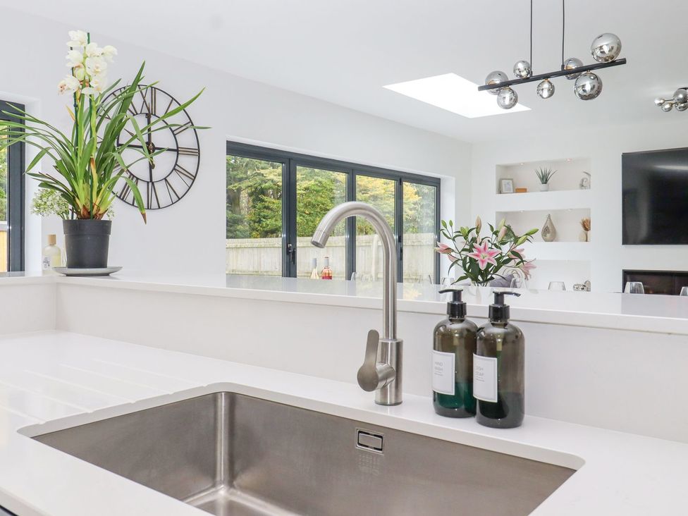 A kitchen with sink and wall clock at Berisal in Ashford