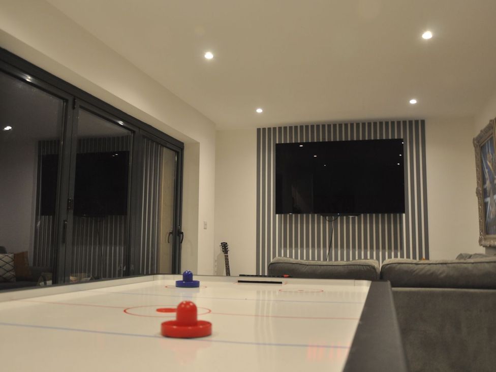 A game room with an air hockey table and a tv at Berisal in Ashford