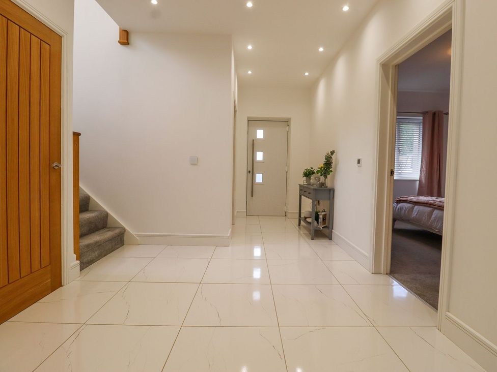 A hallway with a staircase and door at Berisal Ashford