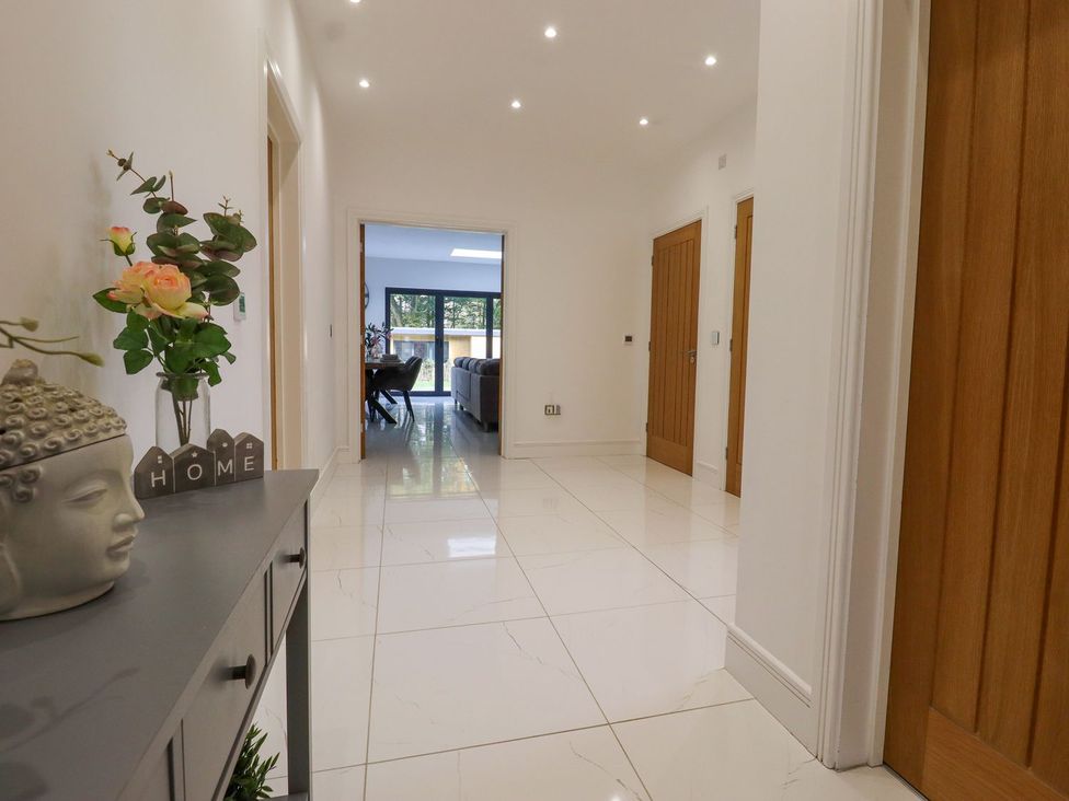 A hallway with a plant and a buddha statue at Berisal in Ashford