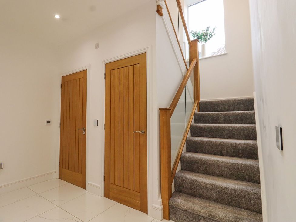 A hallway with stairs and doors at Berisal in Ashford