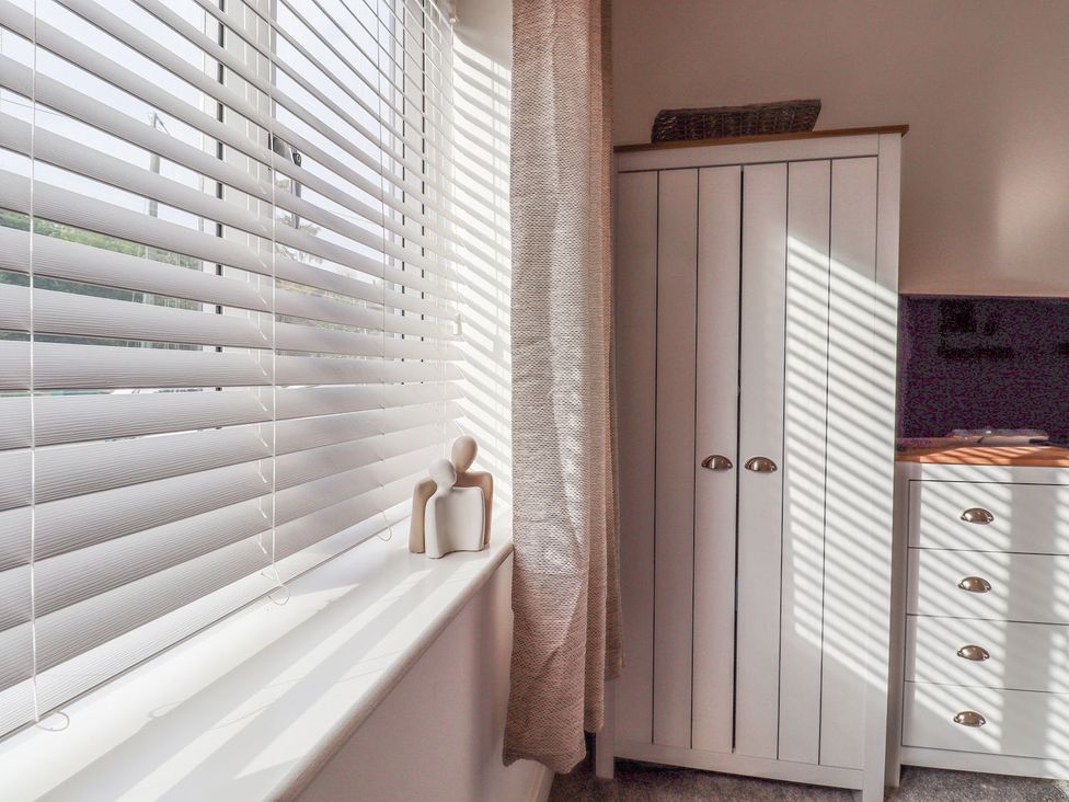 A bedroom with a wardrobe and window blinds at Berisal in Ashford