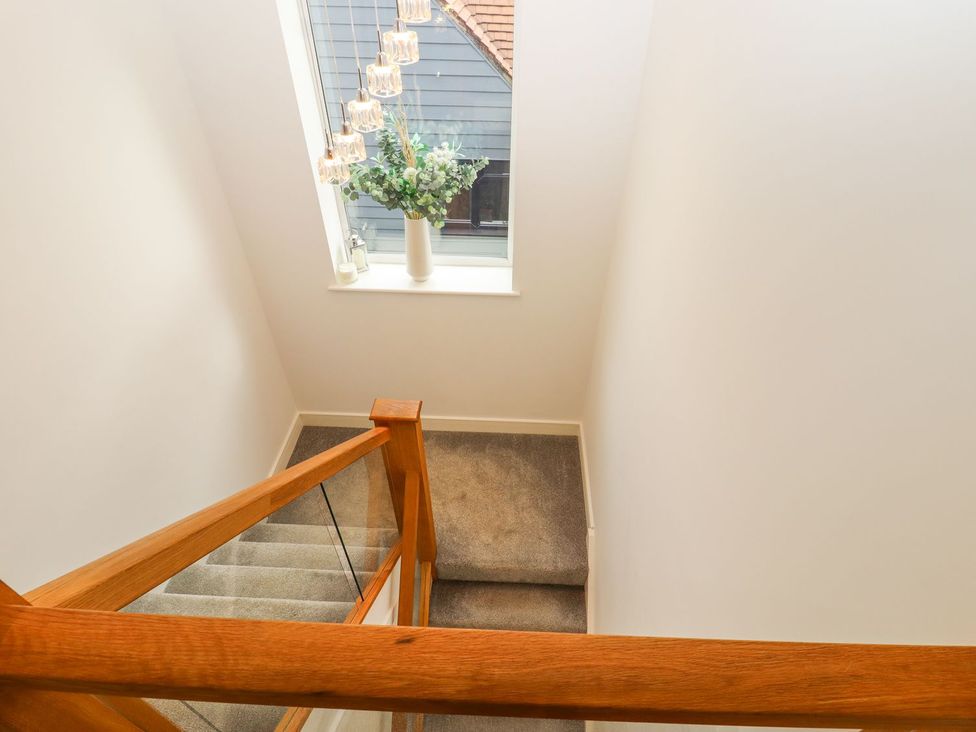 A staircase with a window and flower arrangement at Berisal in Ashford