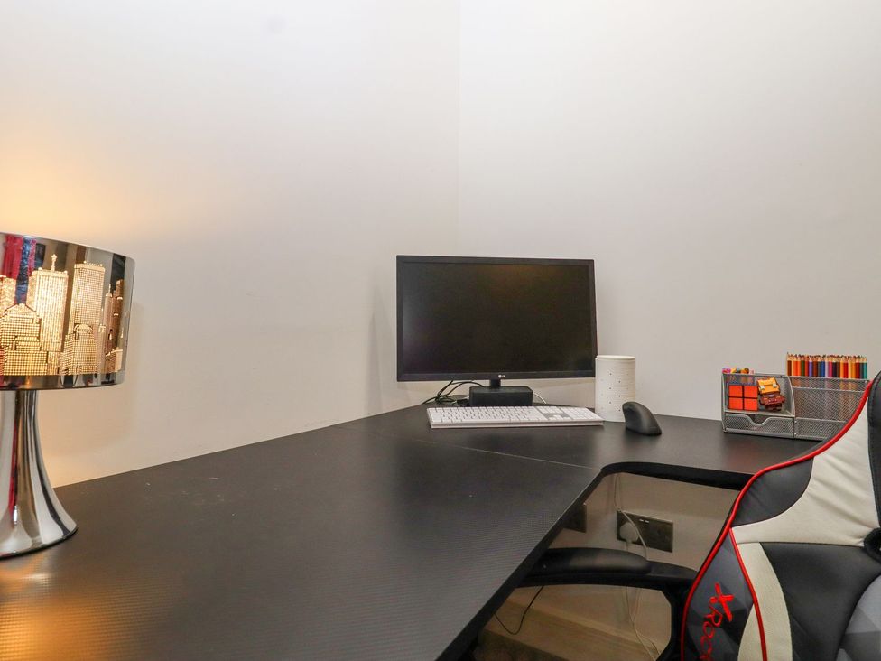 An office desk with a computer monitor and lamp at Berisal in Ashford