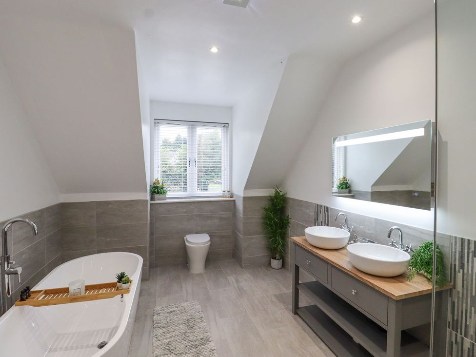 A bathroom with a double sink and bathtub at Berisal in Ashford