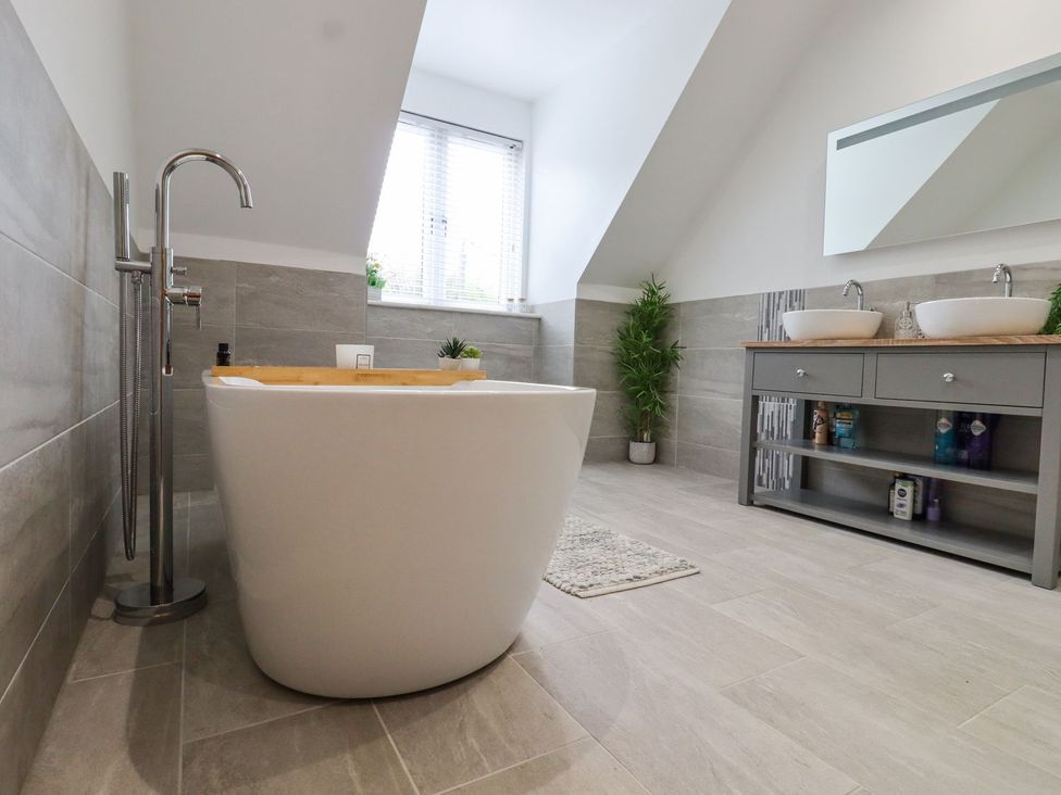 A bathroom with a bathtub and sink at Berisal in Ashford