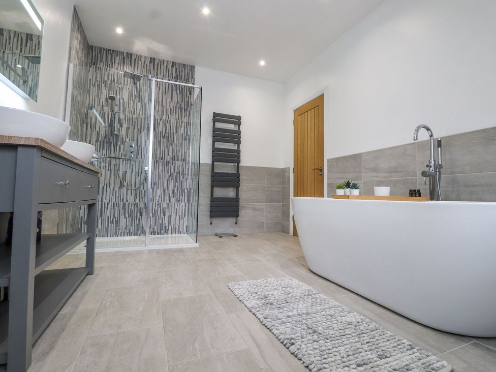 A bathroom featuring a bathtub, shower, and sink at Berisal in Ashford