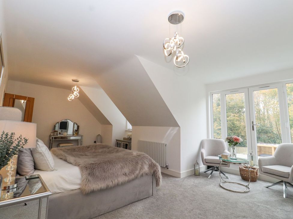 A bedroom with a bed and chairs at Berisal in Ashford