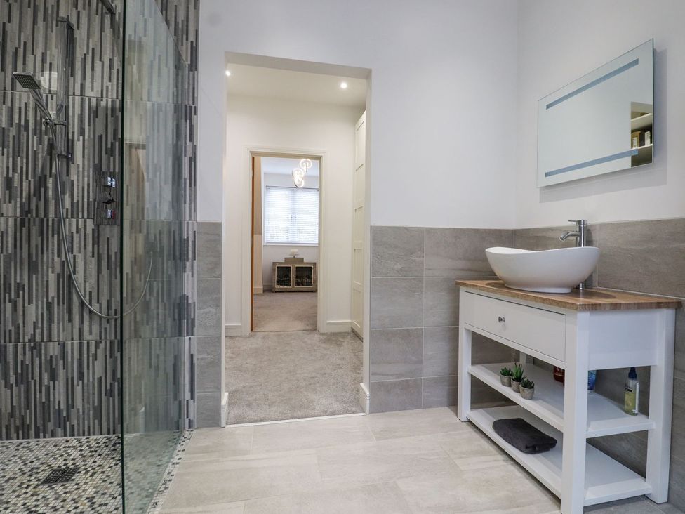 A bathroom with a shower and a vanity sink at Berisal in Ashford