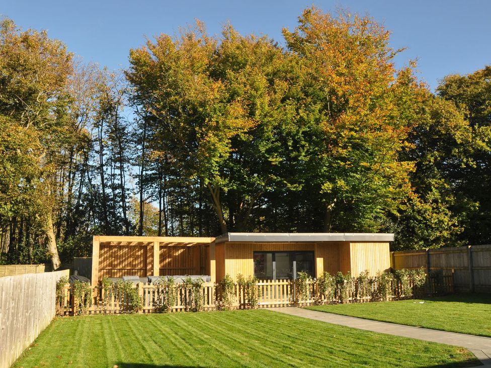A garden with a wooden shed and trees at Berisal in Ashford