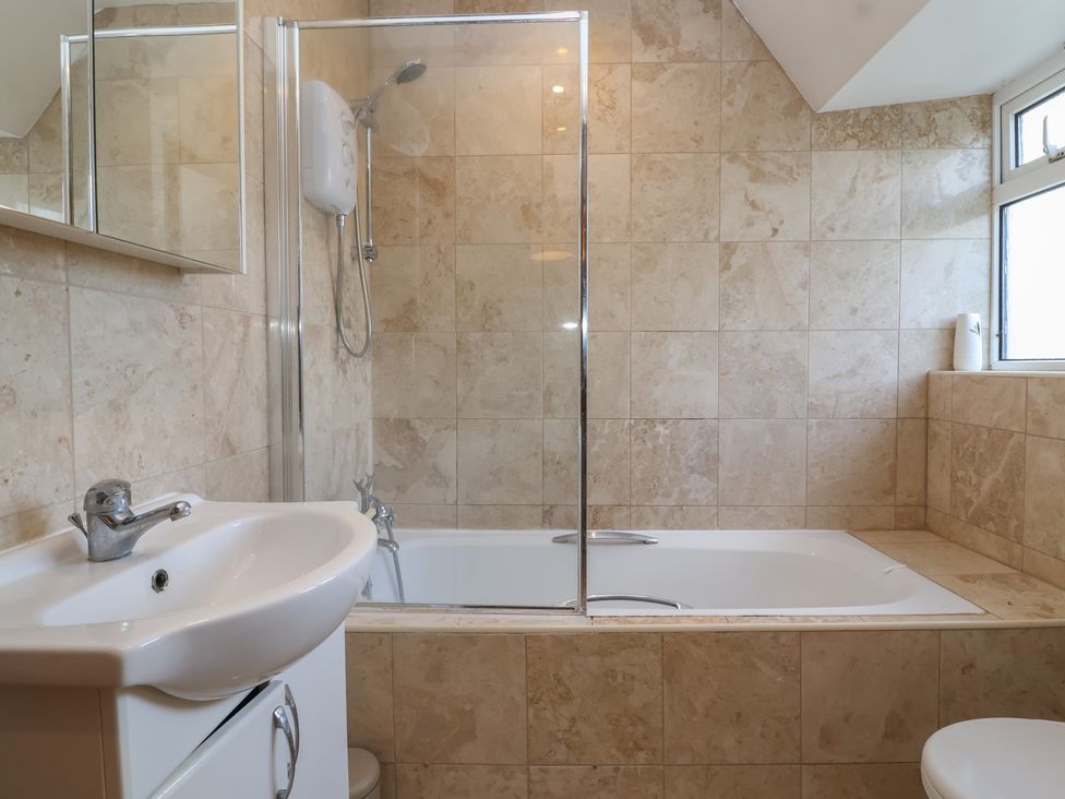 A bathroom with a bathtub, shower, sink, and toilet at 19 Hailey Road