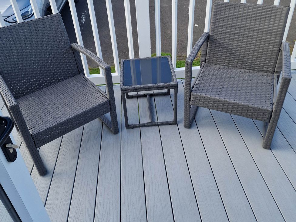 A balcony with two chairs and a table at Gosling 14 in Cayton Bay