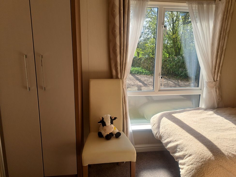 A bedroom with a window and chair at Chapel Farm Static Caravan Holiday Park Lucky Lodge 7 Appleby-in-Westmorland