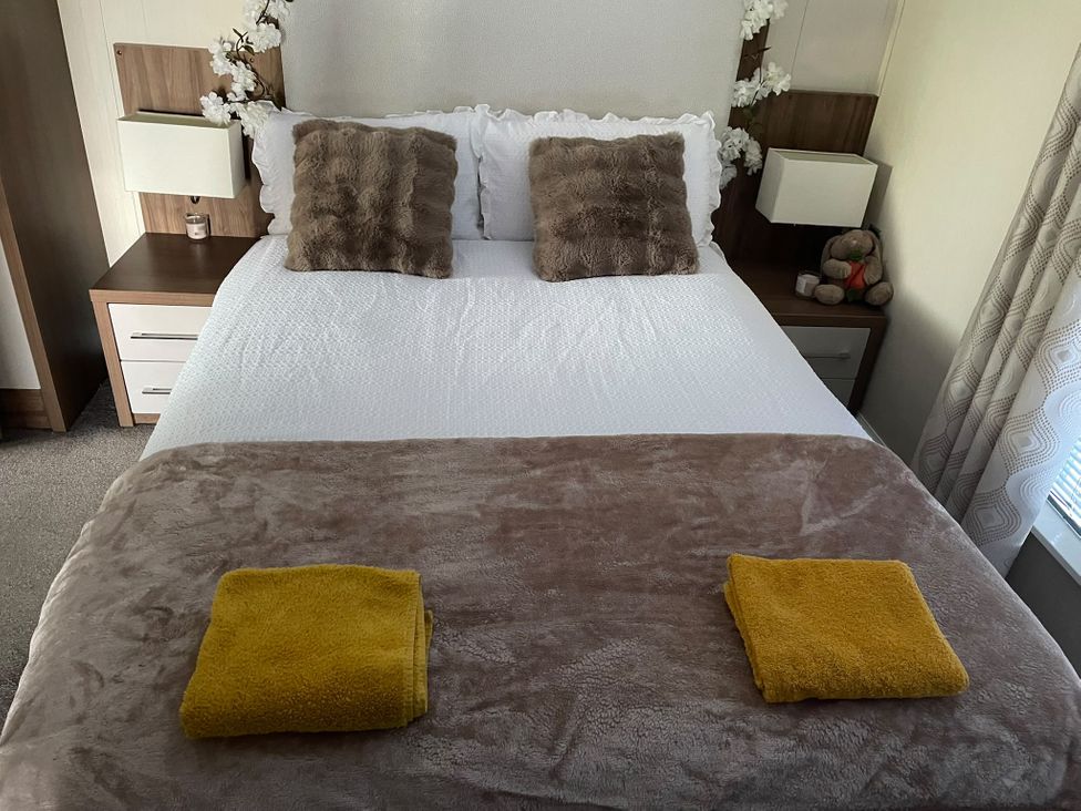 A bedroom with a bed and blankets at Chapel Farm Static Caravan Holiday Park Lucky Lodge 7 Appleby-in-Westmorland