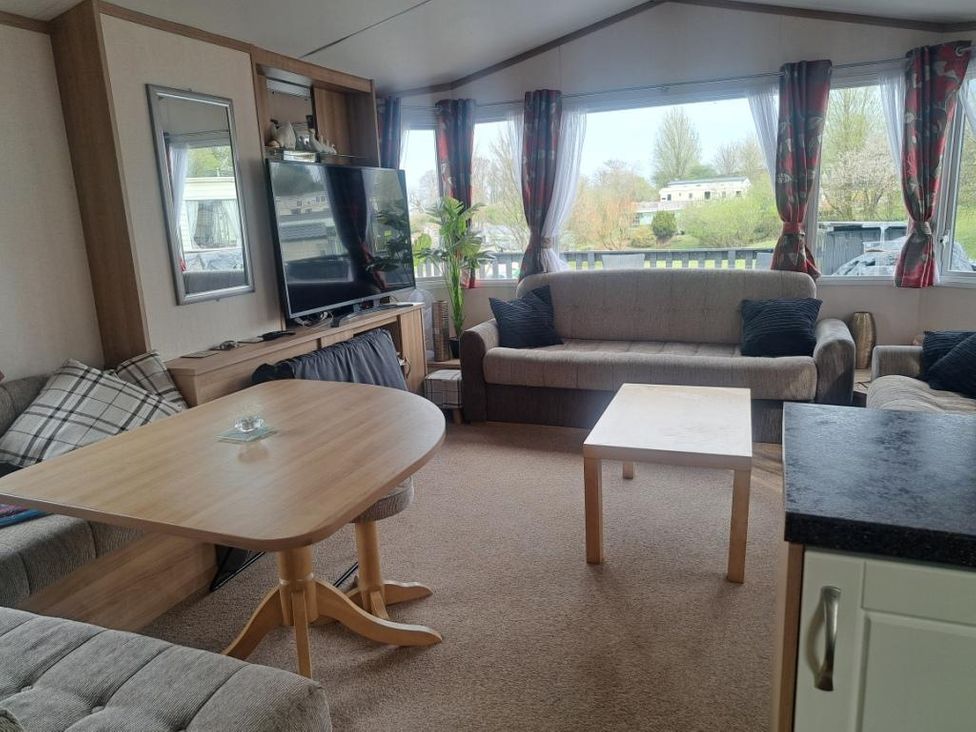 A living room with a television and sofa at Chapel Farm Static Caravan Holiday Park Pennine Views No 17 in Appleby-in-Westmorland