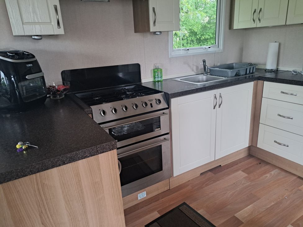 A kitchen with a stove and sink at Chapel Farm Static Caravan Holiday Park Pennine Views No 17 in Appleby-in-Westmorland