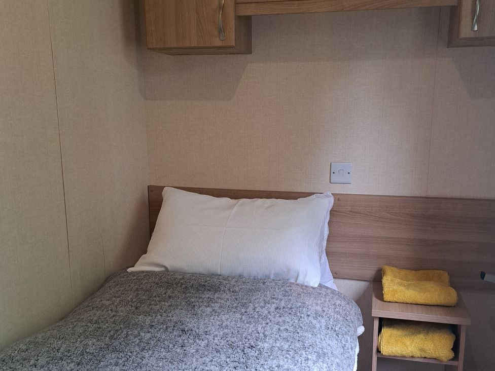 A bedroom with a bed and towels at Chapel Farm Static Caravan Holiday Park Pennine Views No 17 Appleby-in-Westmorland