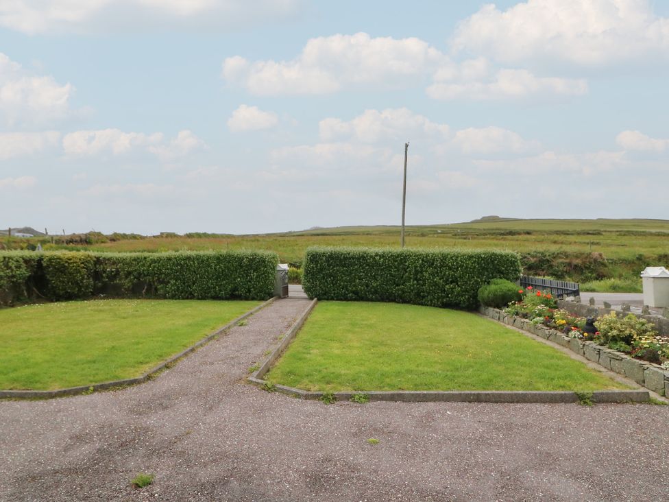 An outdoor area with hedges and a flower bed at Wild Atlantic Way Country Cottage, Portmagee, County Kerry