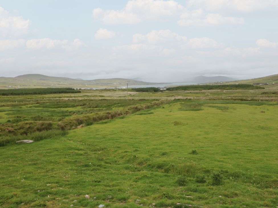 A landscape view with grass fields and distant hills at Wild Atlantic Way Country Cottage, Portmagee, County Kerry