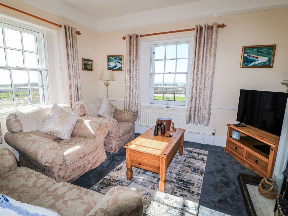A living room with a coffee table and sofa at Old Higher Lighthouse Stopes Cottage Portland Bill